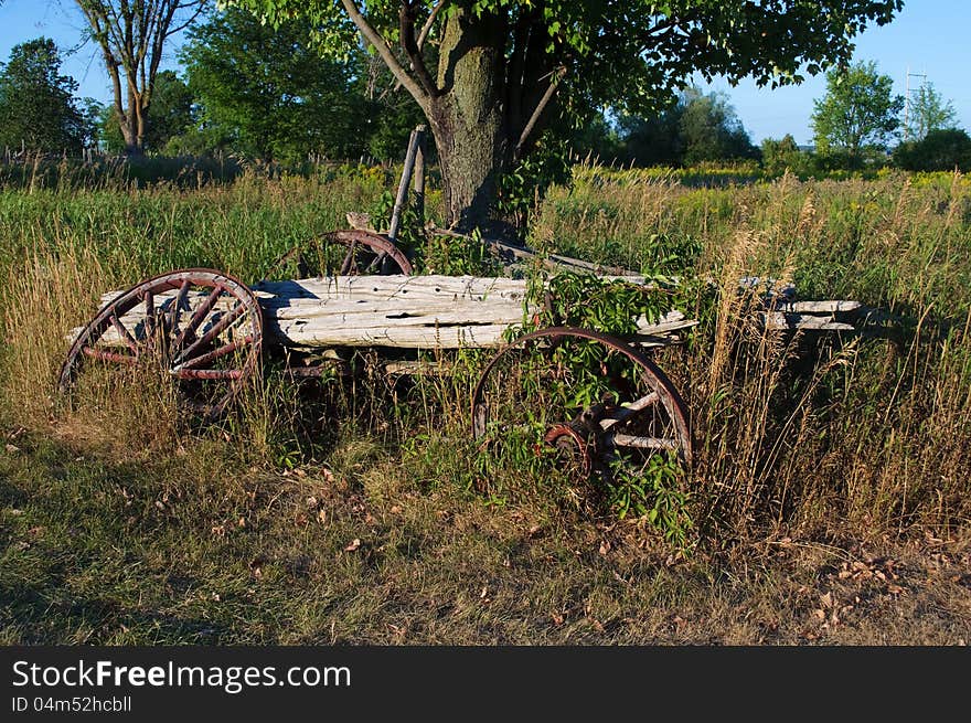 Wreck of an old horse-drawn wagon rotting in a farmer's field. Wreck of an old horse-drawn wagon rotting in a farmer's field