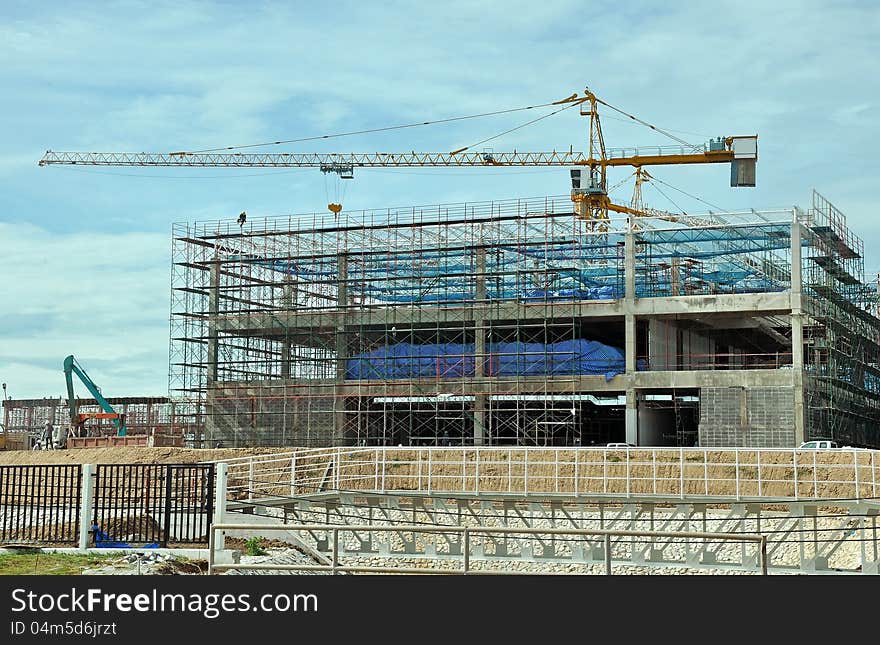 Building under construction with hanging worker on top