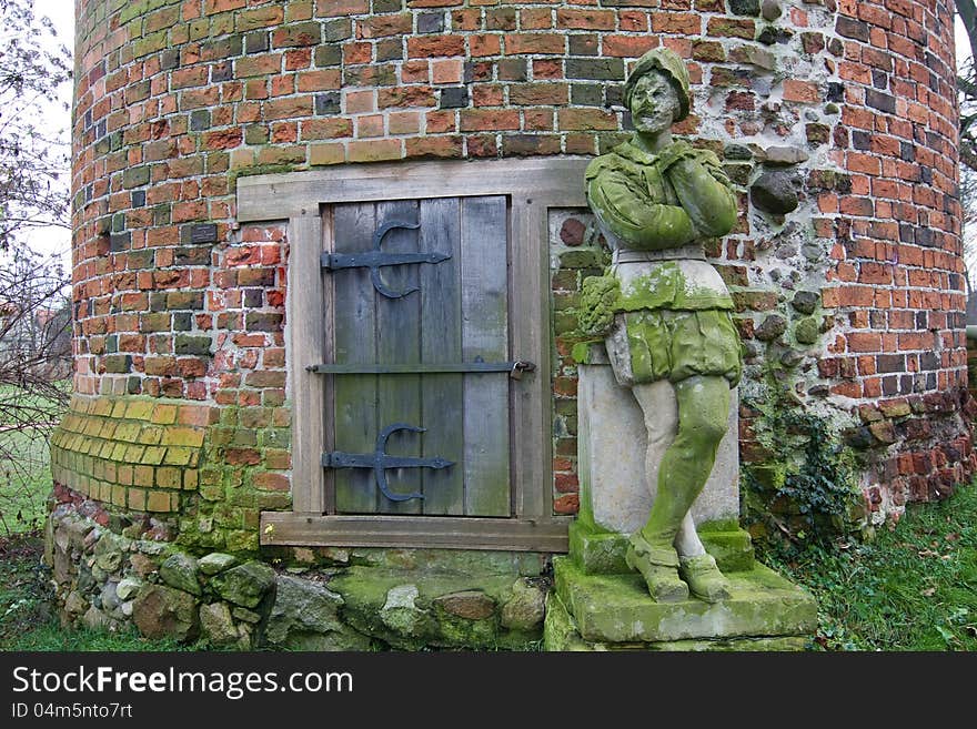 City guardian made of stone before a tower. City guardian made of stone before a tower