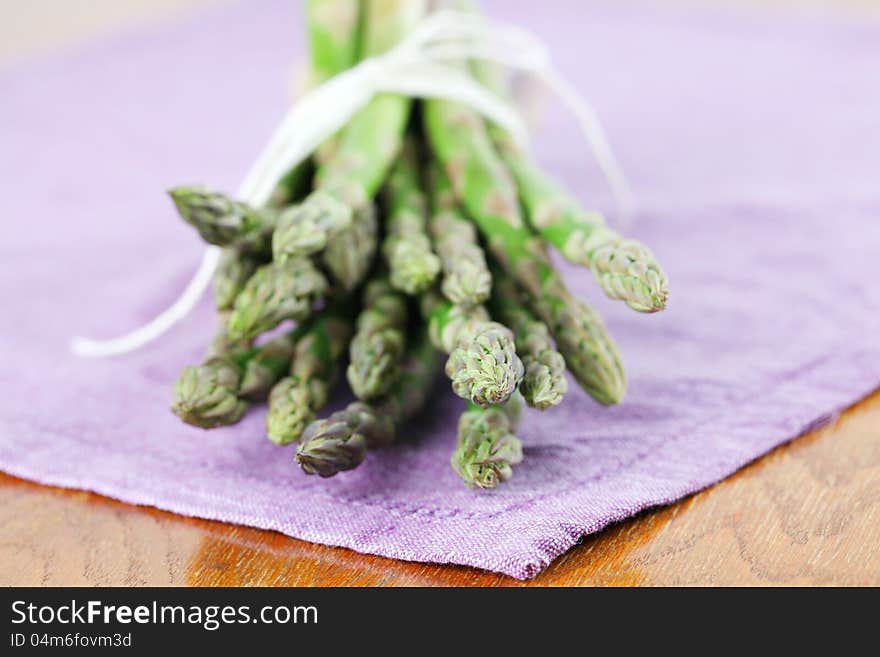 Green asparagus on purple napkin. Shallow dof