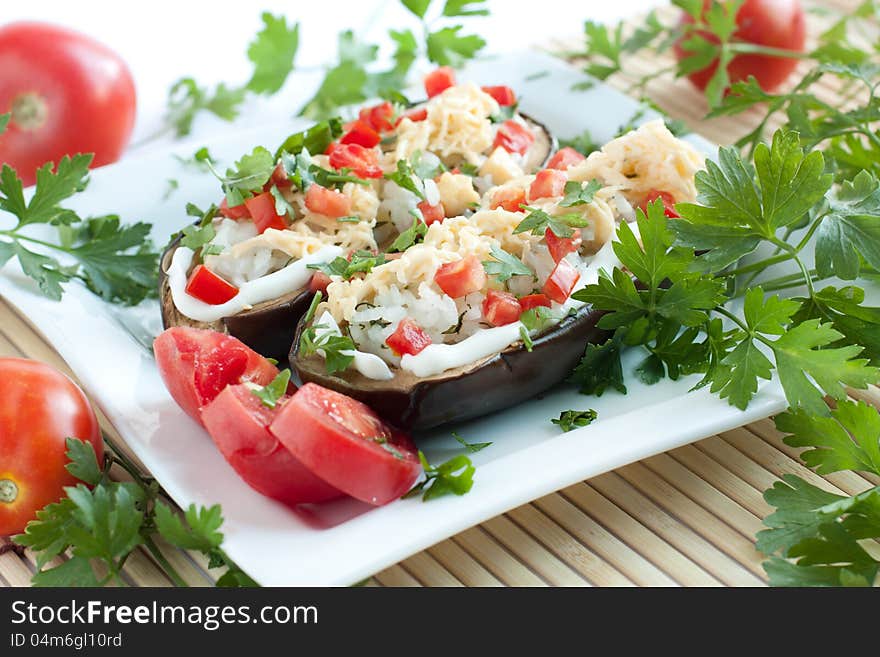 Cooked aubergines  on a white square plate