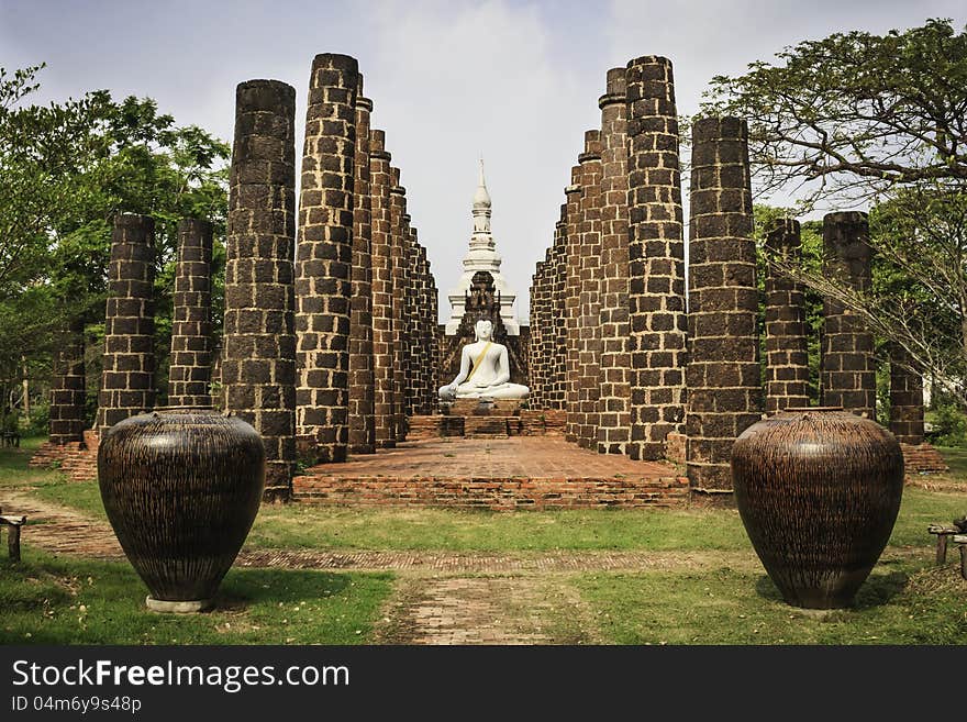 A White sitting Buddha statue red pillar brick  in Thailand