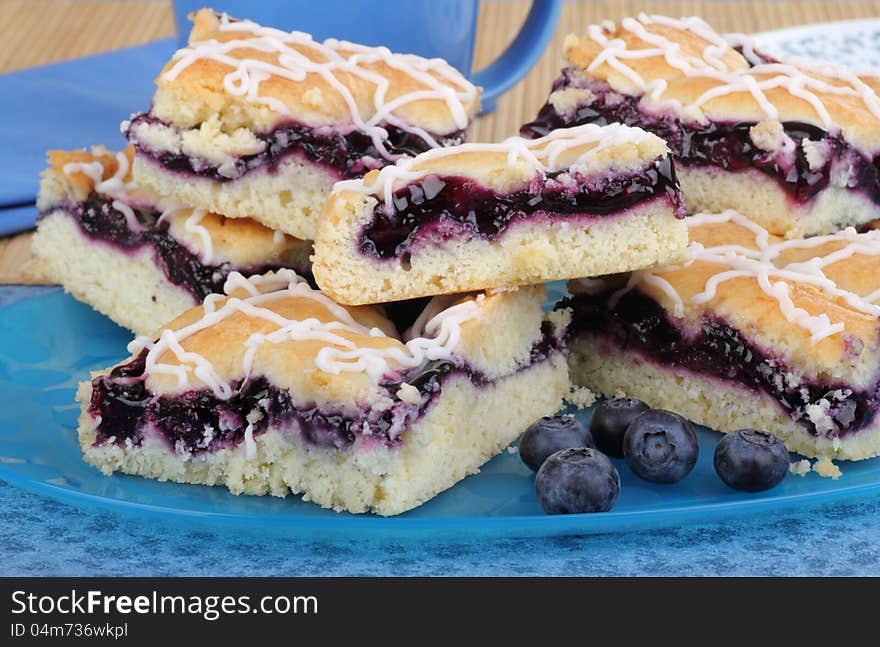 Stacked blueberry bars and berries on a platter