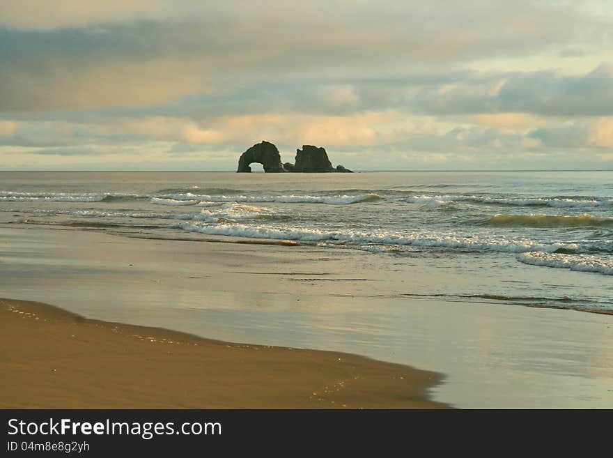 Arches rocks with pink sunset tinges over the Pacific in summertime Oregon. Arches rocks with pink sunset tinges over the Pacific in summertime Oregon