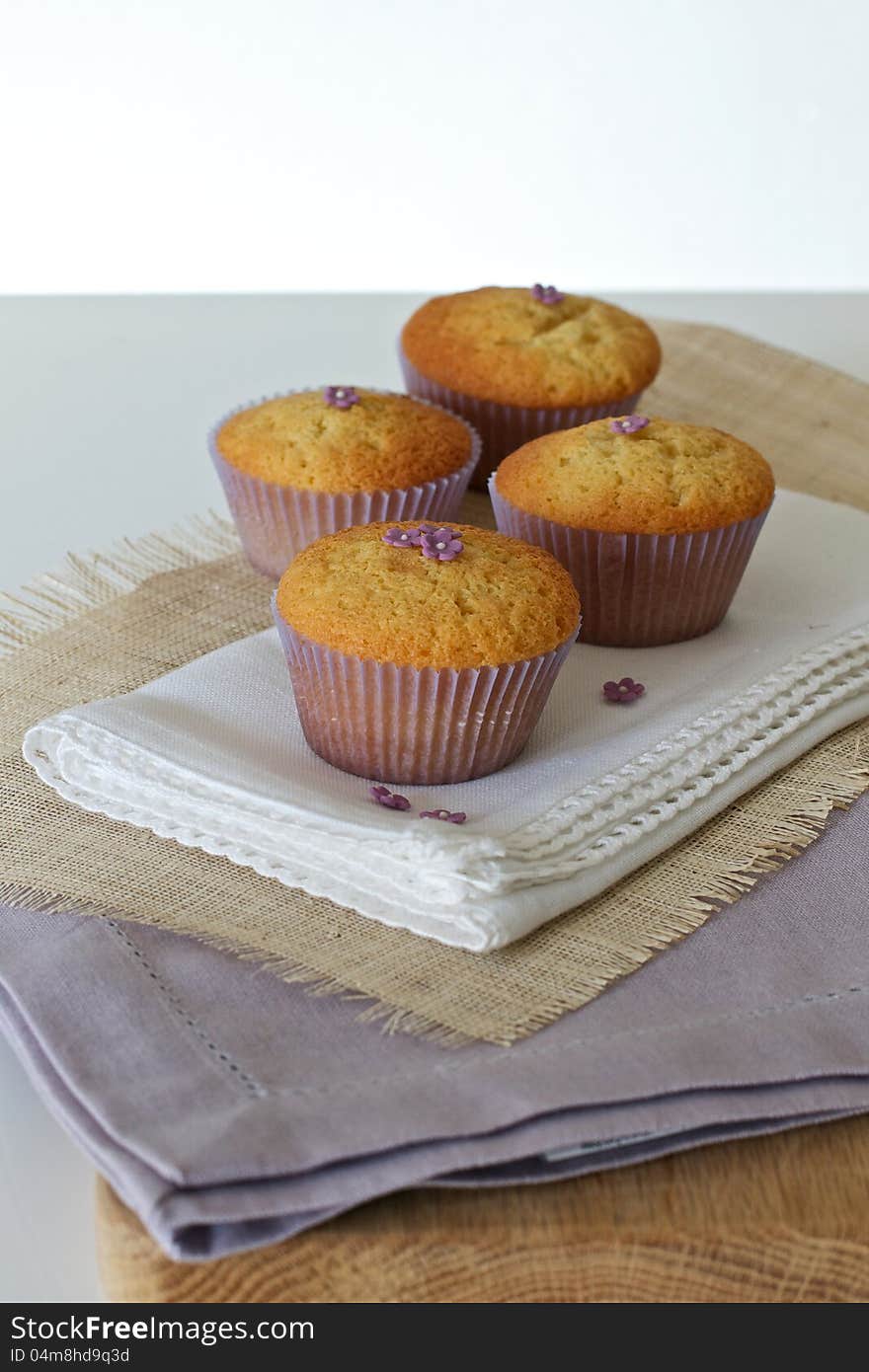 Cupcakes with daisies on hessian and serviettes