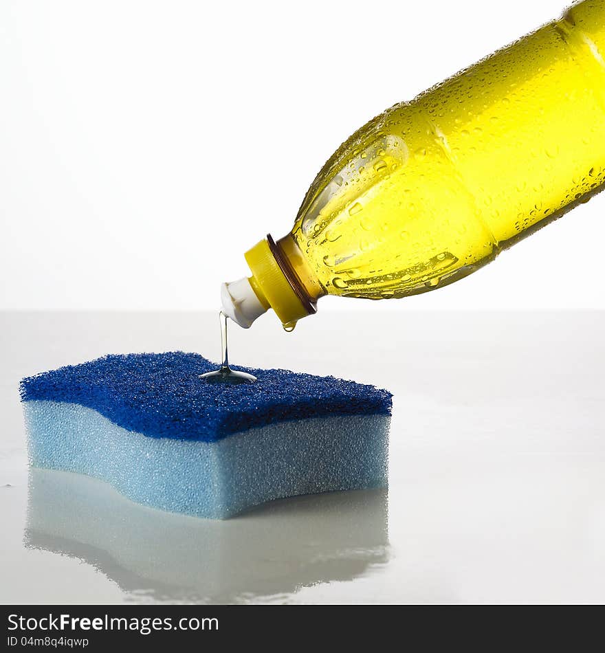 Pouring detergent into a kitchen sponge. Pouring detergent into a kitchen sponge