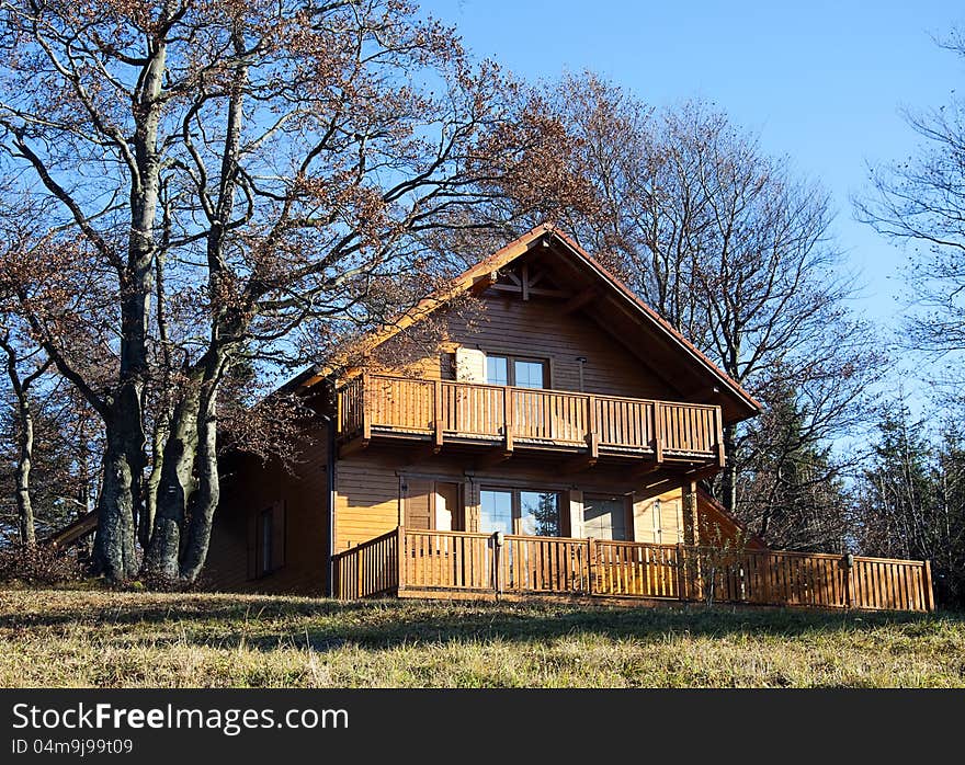 Wooden chalet or a weekend house on the edge of a forest at the autumn or fall season. Wooden chalet or a weekend house on the edge of a forest at the autumn or fall season.