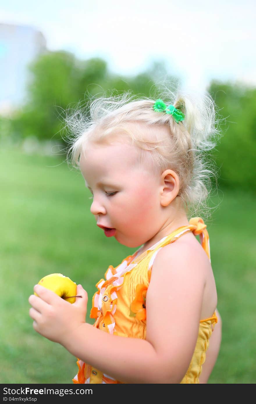 Portrait of a girl with an apple in the park