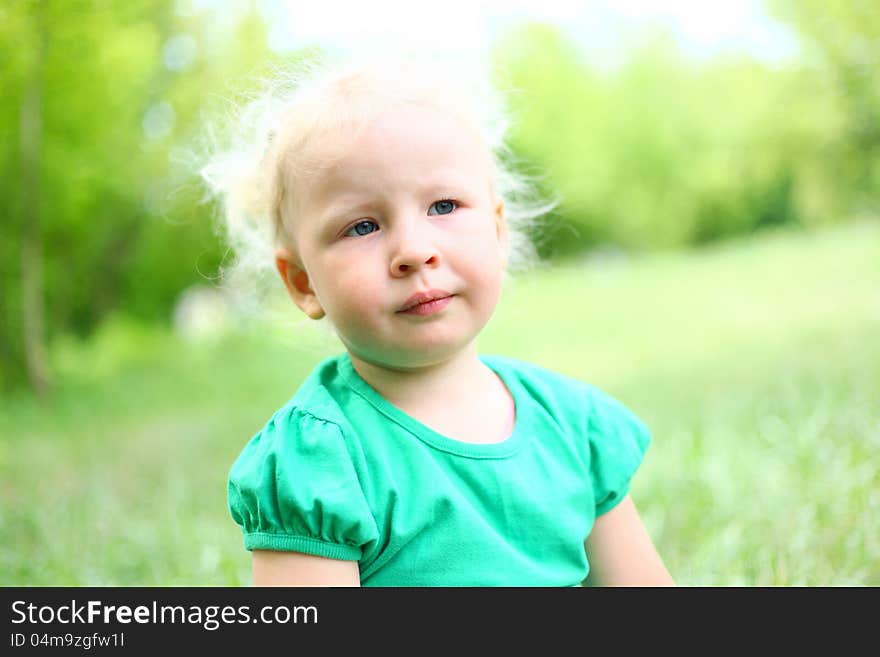 Portrait of a girl child blond in park