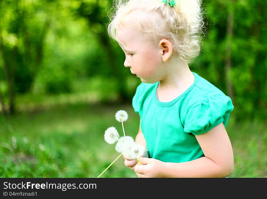 Portrait of a girl in the park with dandelions day