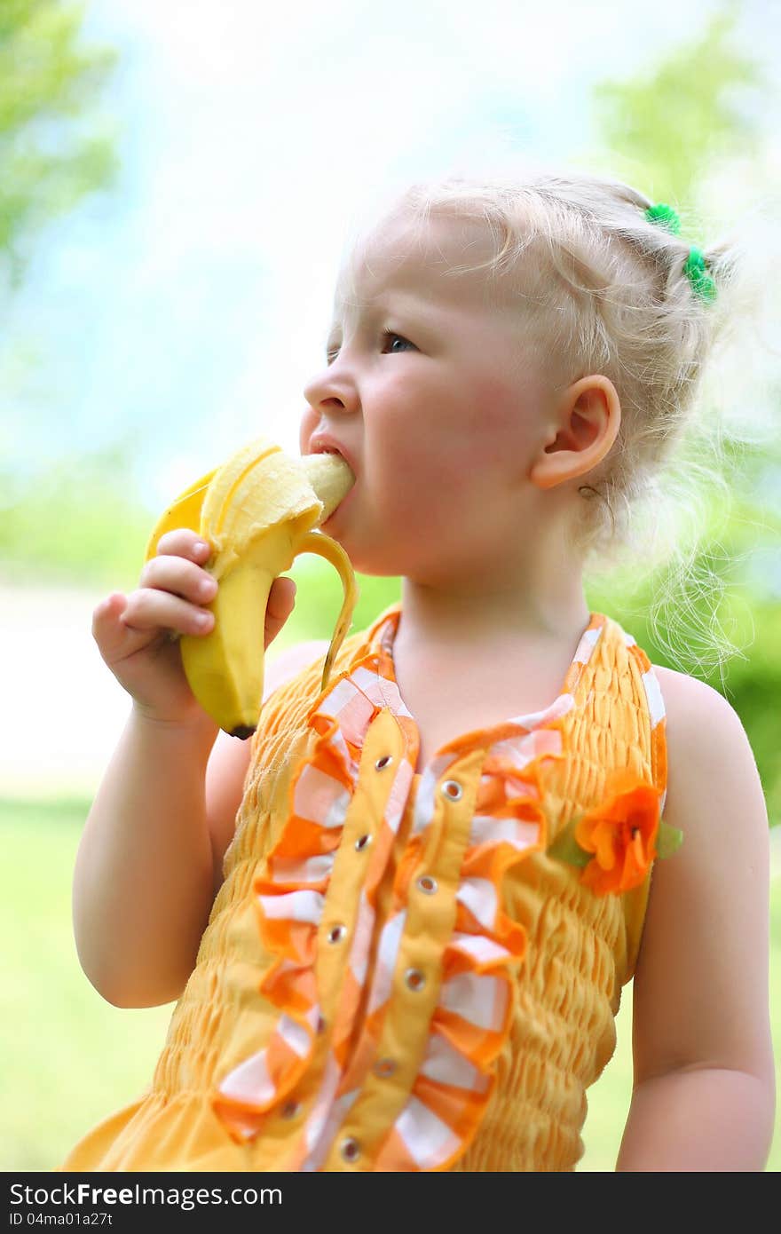 Portrait of a pretty girl eat a banana in the park