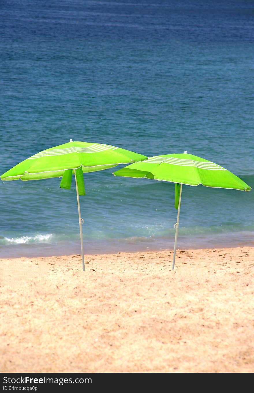 Two green sun umbrellas on the beach