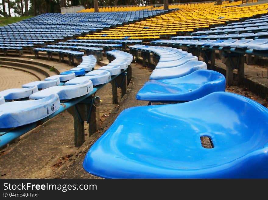 In the open air amphitheater with blue and yellow chairs. In the open air amphitheater with blue and yellow chairs