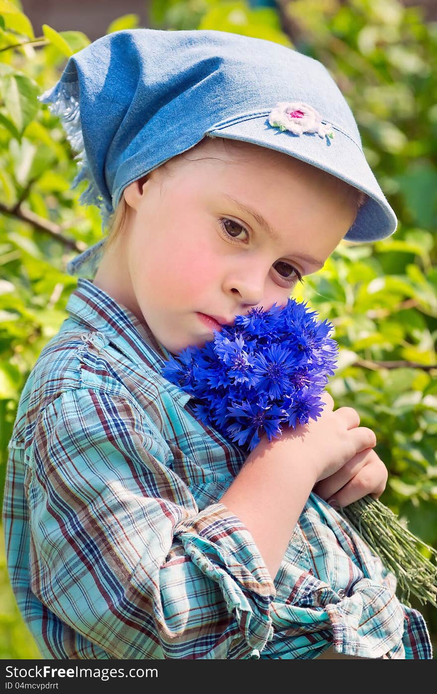 The sad child with a bouquet of wild flowers. The sad child with a bouquet of wild flowers