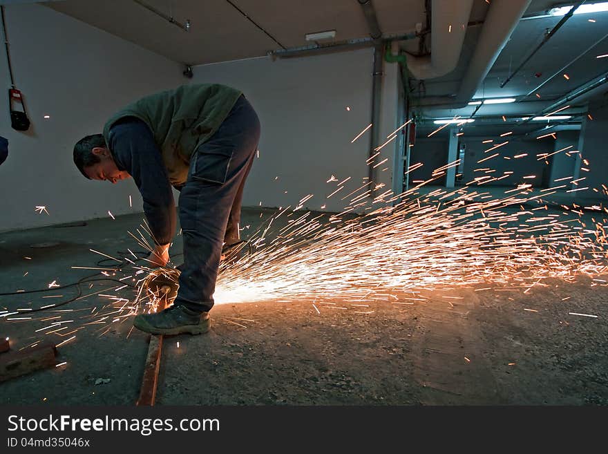 Man with a metal grinder grinding, sparks