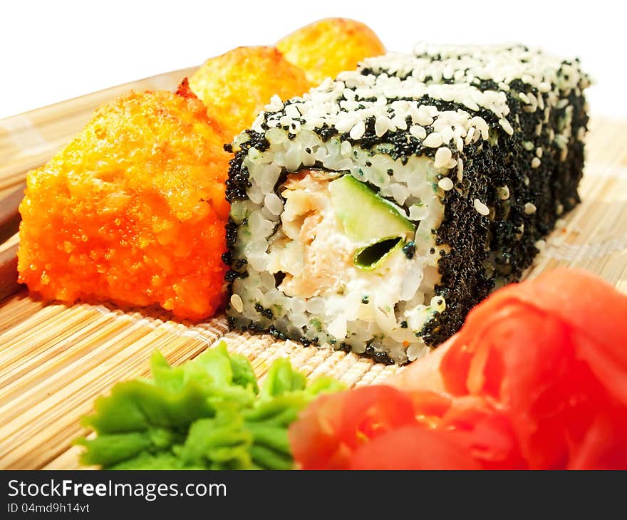 Rolls with black roe and sesame and baking sushi on bamboo mat