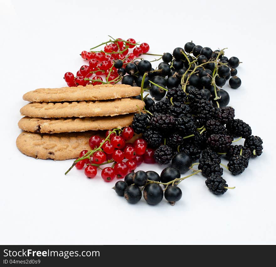 Black and red currants, mulberry and cereal biscuits on a white background