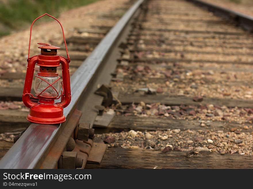 A vintage railroad lamp on a set of railroad tracks. A vintage railroad lamp on a set of railroad tracks.