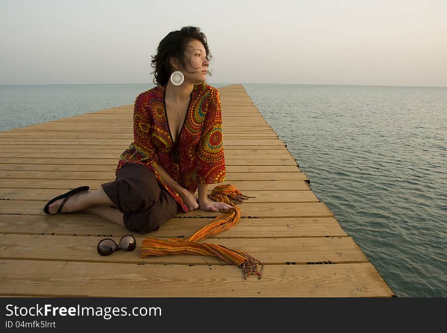 Girl sitting on pier in the morning. Girl sitting on pier in the morning