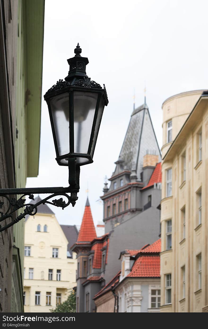 Vintage street lamp on city background with red tiling roofs