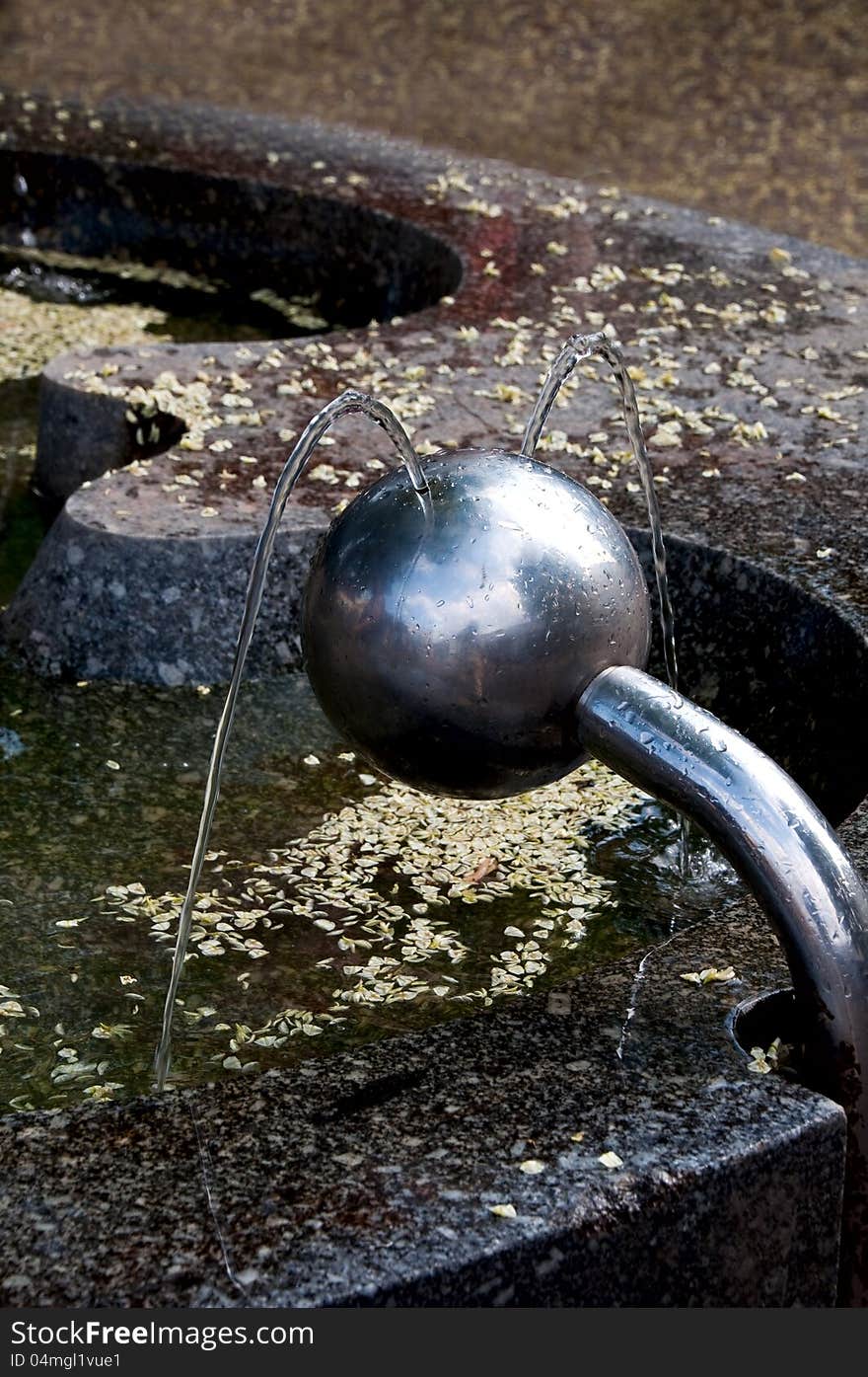 Drinking fountain in the form of a ball beating in two streams