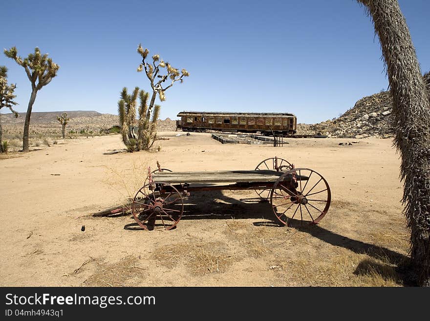 Burned out railroad car and old wagon in the California desert. Burned out railroad car and old wagon in the California desert