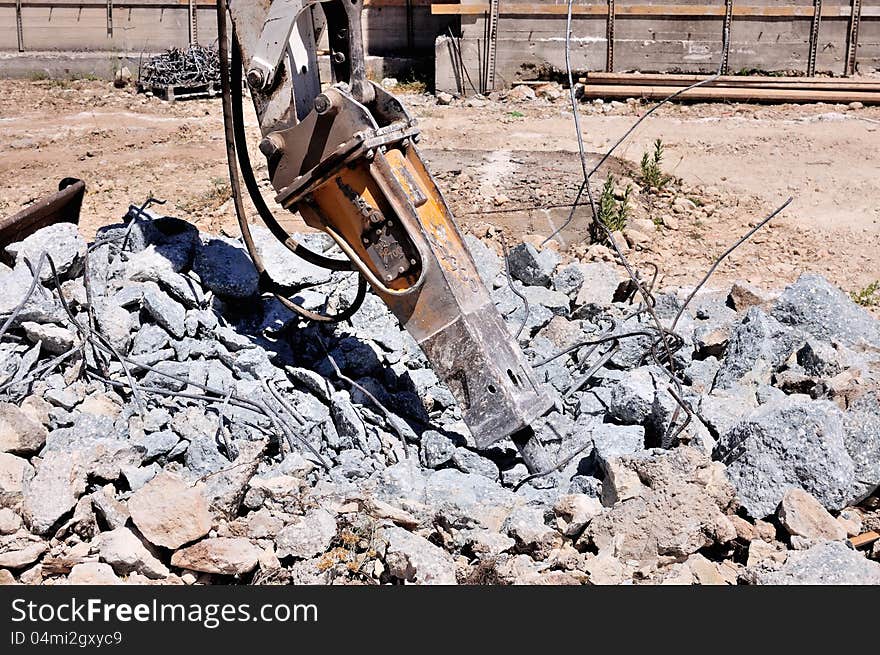 Excavator with hammer demolishes