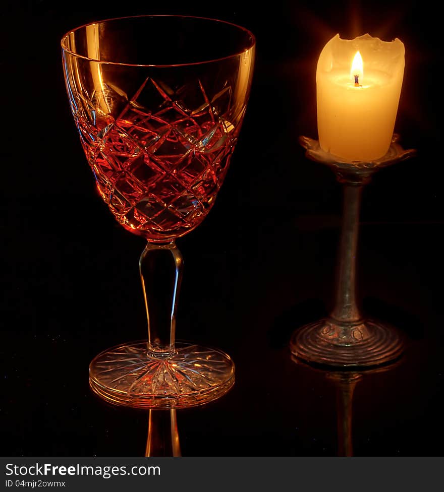 A wine glass lit by a singe candle. A wine glass lit by a singe candle