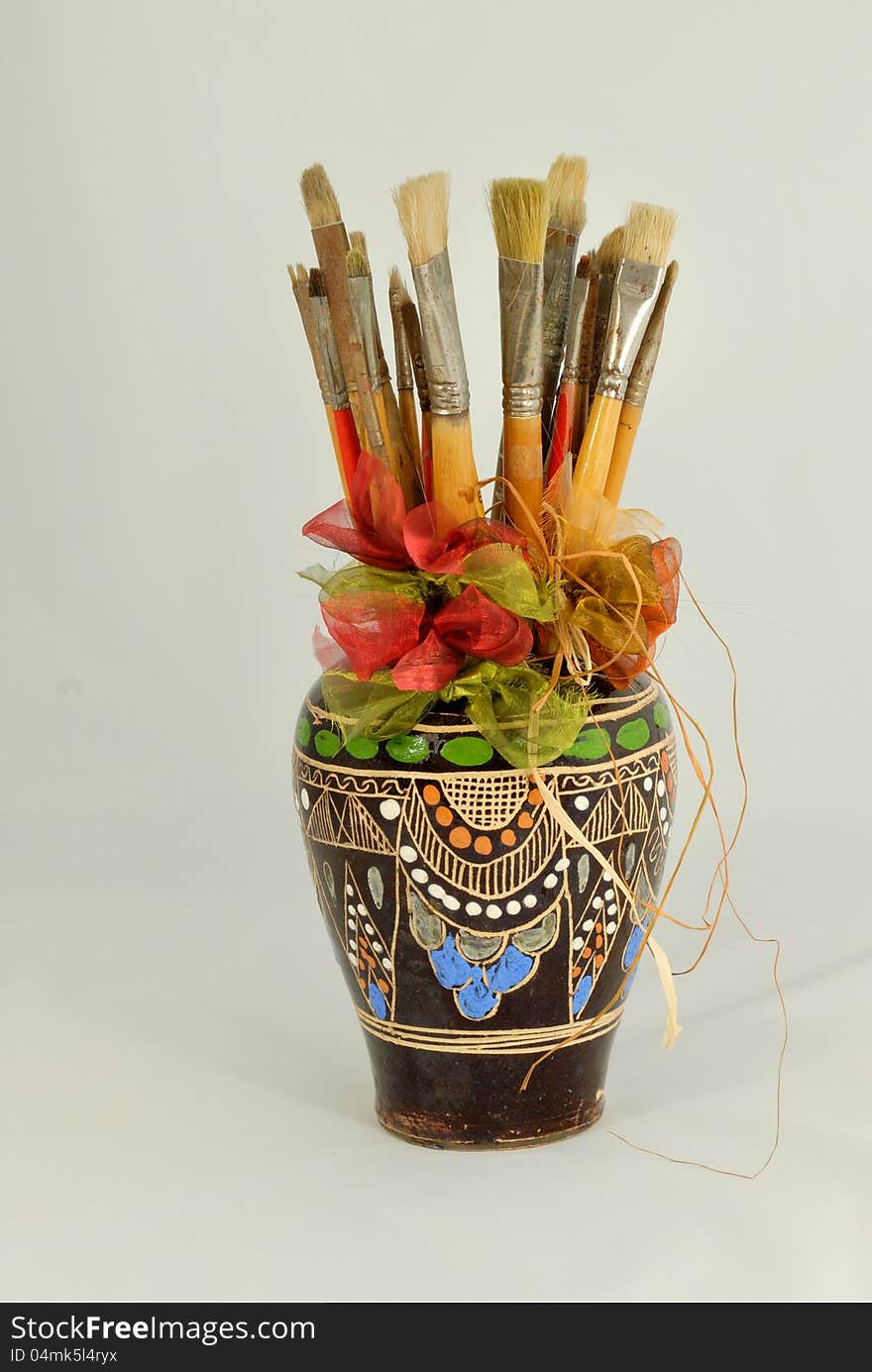 Paint brushes in decorated vase. Paint brushes in decorated vase.