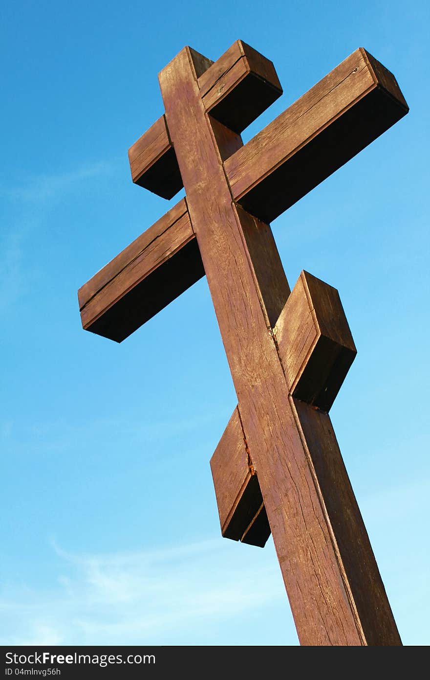 The wooden cross on a blue sky background