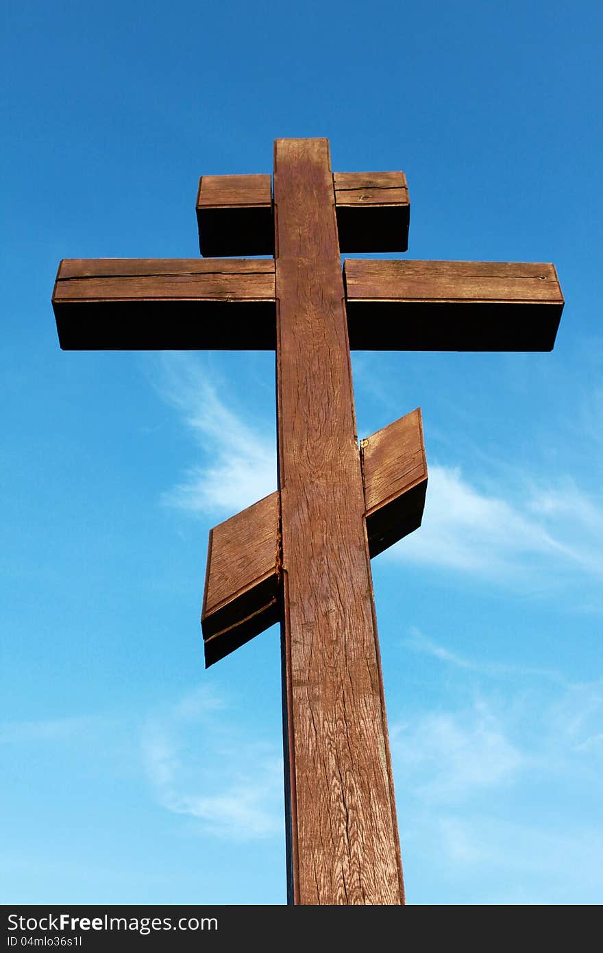 The wooden cross on a blue sky background