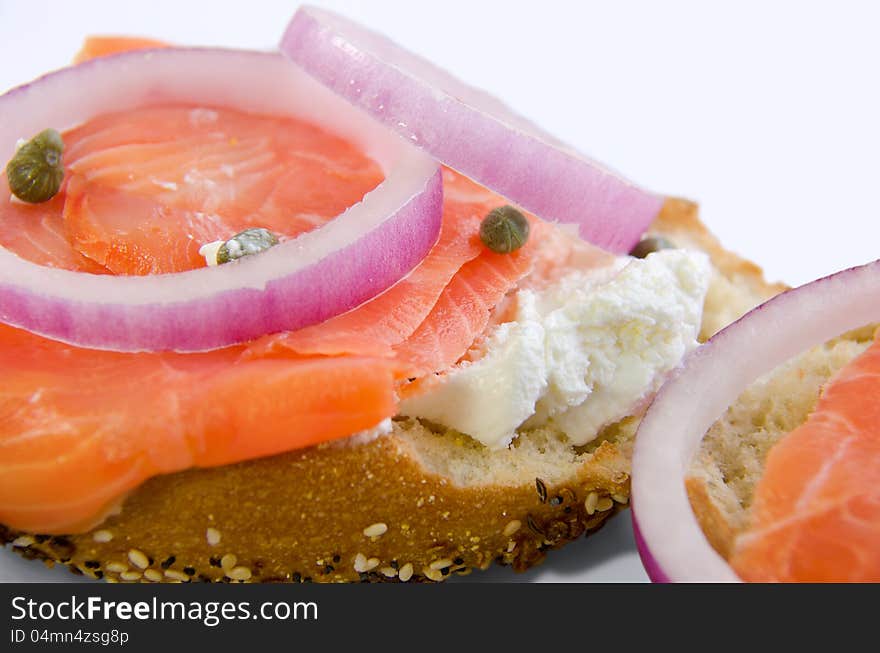 Lox and cheese with capers and onions on a toasted bagel that is covered with seeds. Lox and cheese with capers and onions on a toasted bagel that is covered with seeds