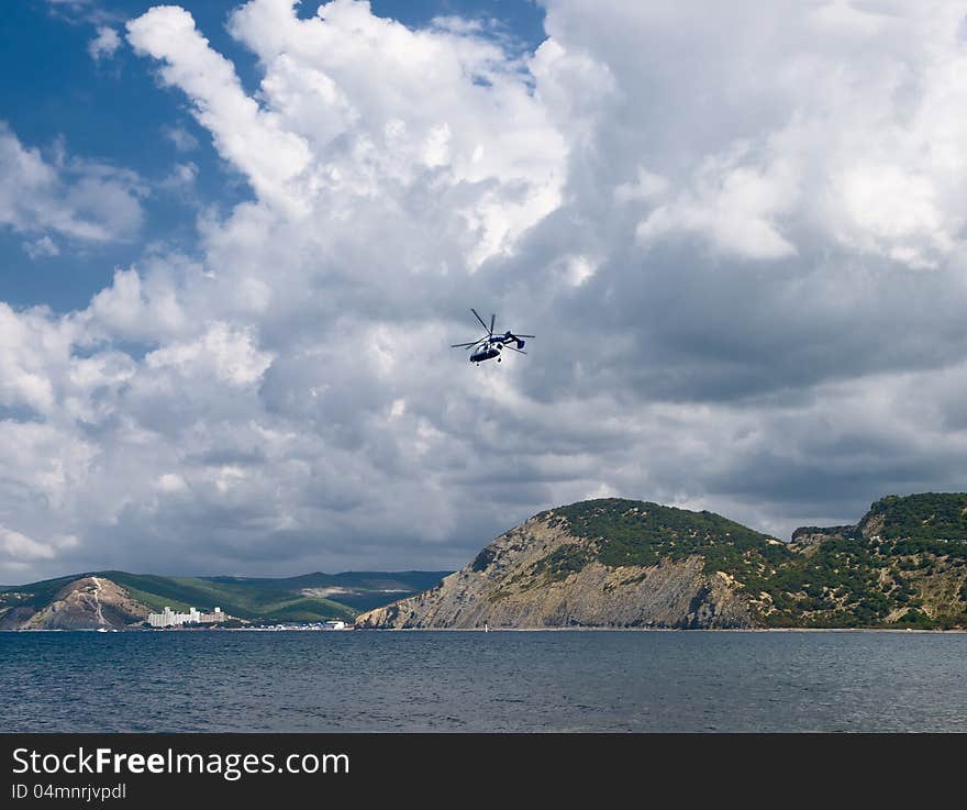 Summer landscape with sea, rocks, cloudscape and helicopter. Summer landscape with sea, rocks, cloudscape and helicopter