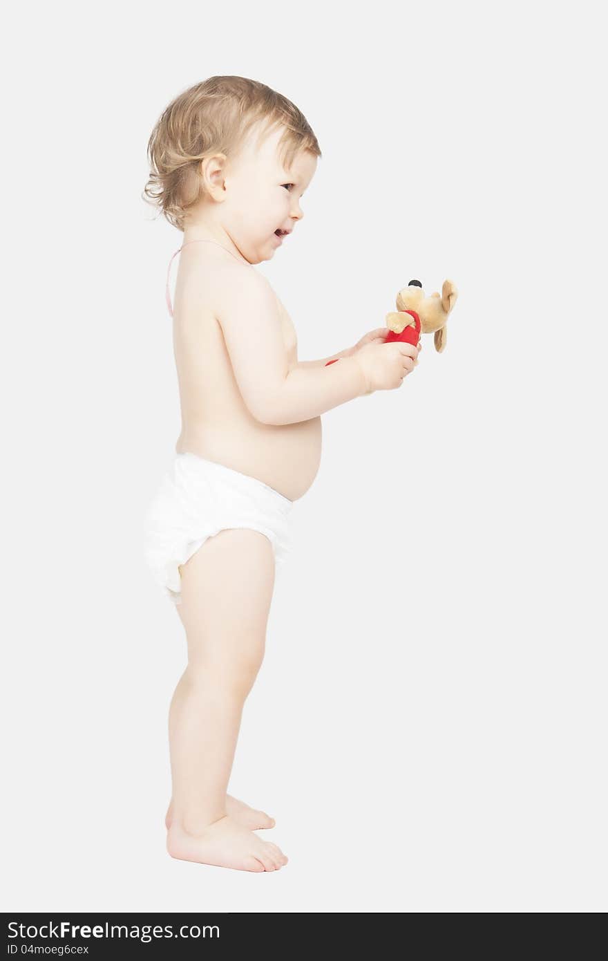 Portrait of cute little caucasian girl in pants standing and holding toy. Portrait of cute little caucasian girl in pants standing and holding toy