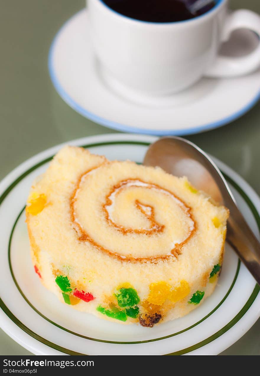 Closeup of roll sponge cake, focus on fruit garnis