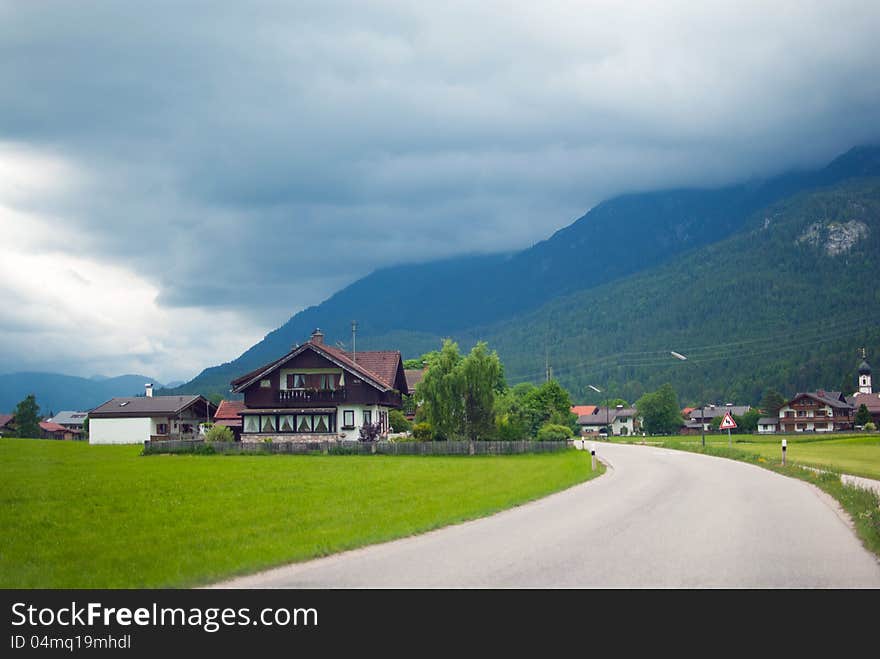 Road through apline village before thunderstorm