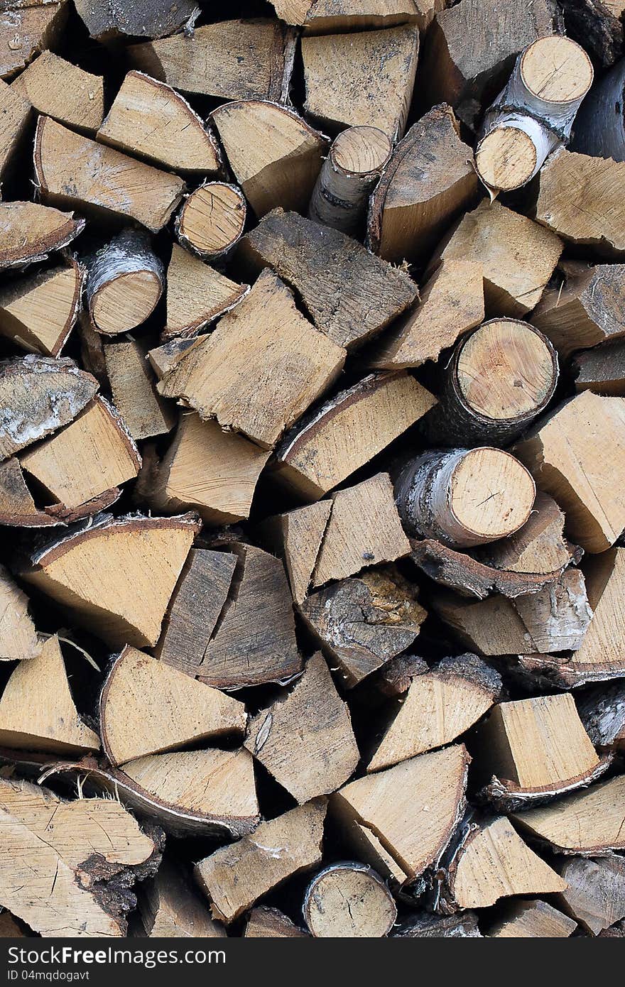 Background of dry chopped firewood logs stacked up on top of each other in a pile. Background of dry chopped firewood logs stacked up on top of each other in a pile