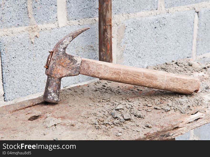 Old hammer on construction background