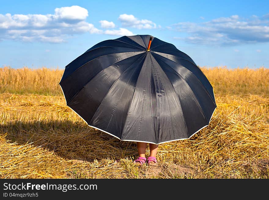 Little girl hiding under umbrella