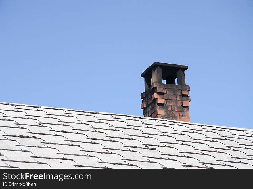 Chimney on tile roof against blue sky. Chimney on tile roof against blue sky