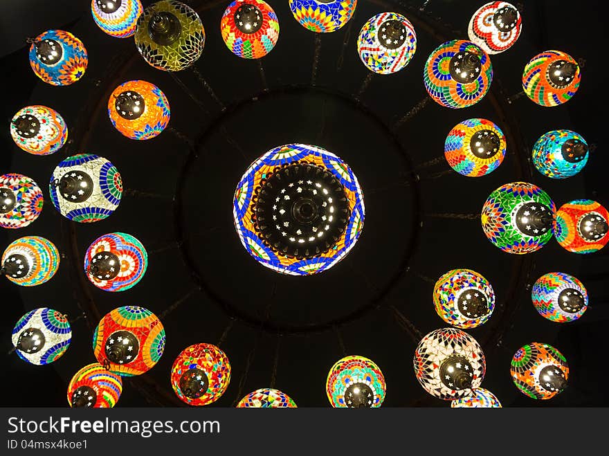 Colorful hanging round glass lamp hang from black background ceiling