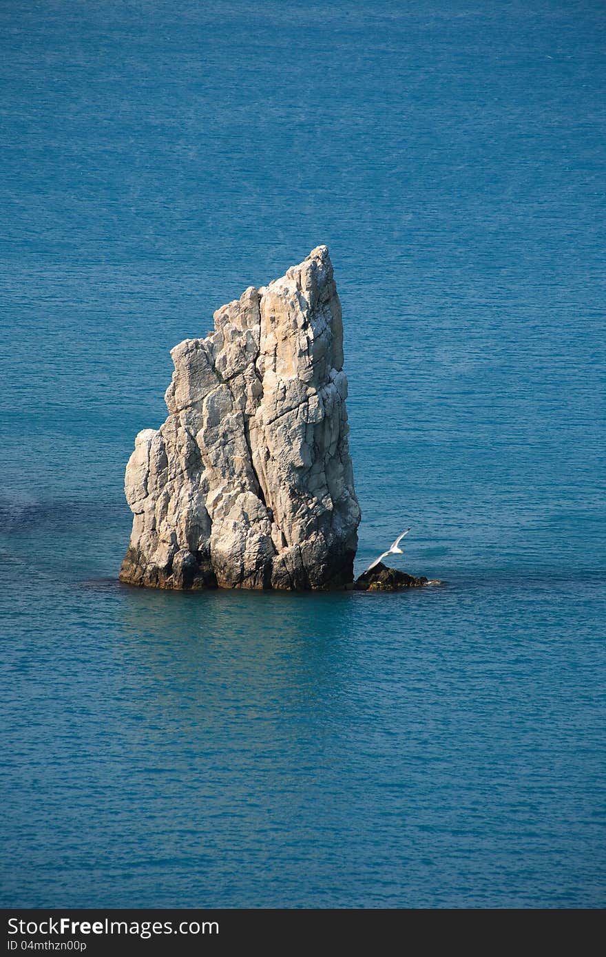 High lonely rock like a sail in a sea. High lonely rock like a sail in a sea