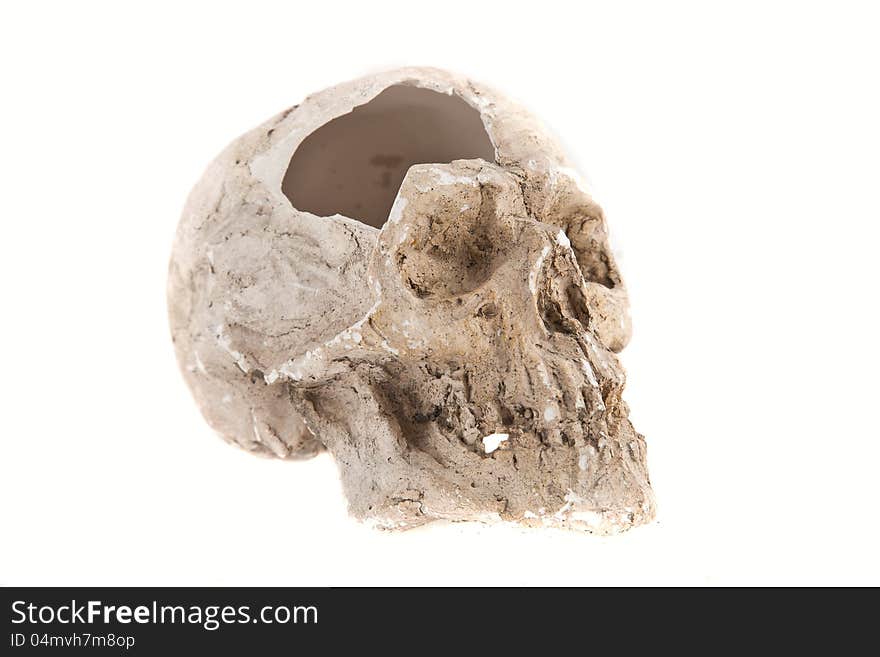 Close up of a broken skull sculpture on white background, made of plaster