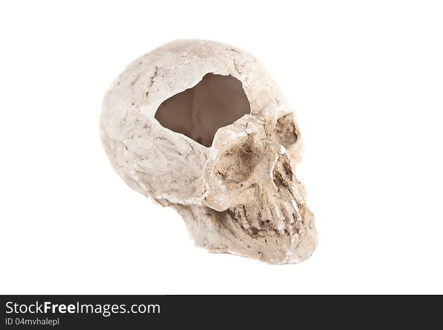 Close up of a broken skull sculpture on white background, made of plaster