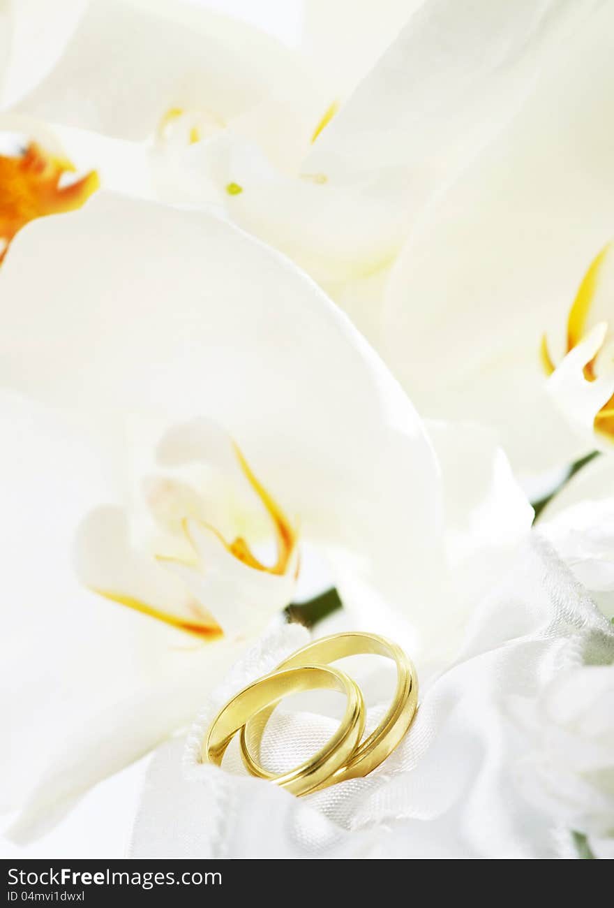 Close up on wedding bouquet (white orchid) and rings. Close up on wedding bouquet (white orchid) and rings