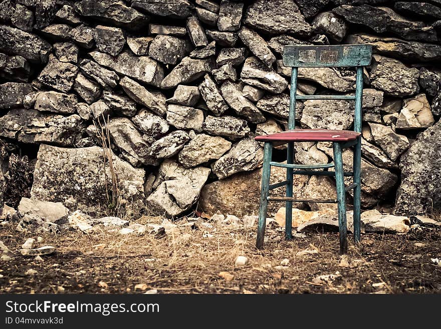 Vintage chair infront of a rock wall. Vintage chair infront of a rock wall.