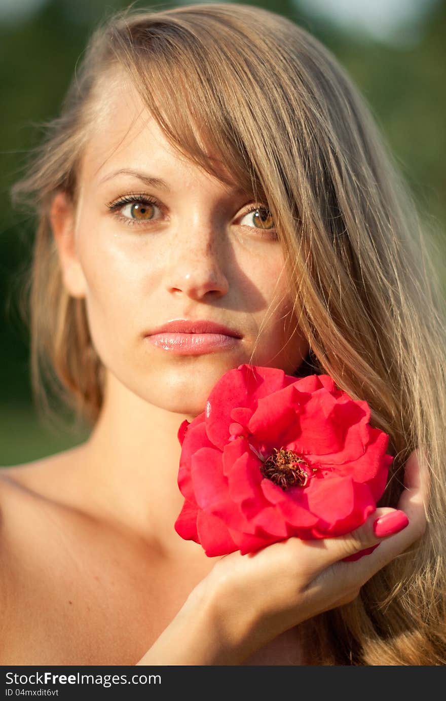 Close-up portrait of young girl with red flower. Close-up portrait of young girl with red flower