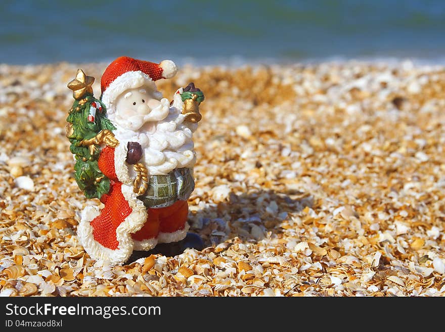 Toy Santa Claus on a summer day at the beach. Toy Santa Claus on a summer day at the beach