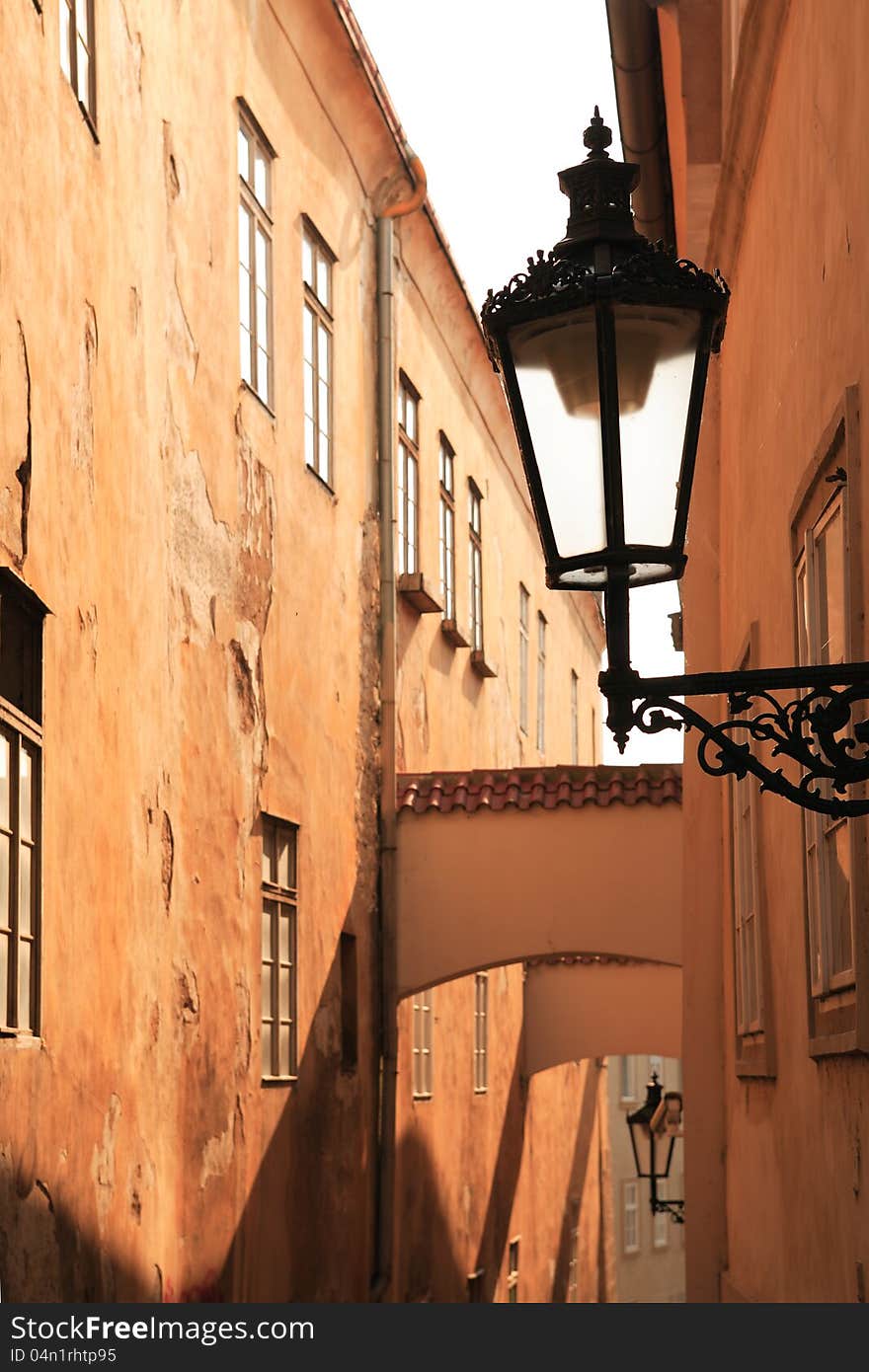 Closeup of vintage street lamp on background with nice old alley at sunrise. Closeup of vintage street lamp on background with nice old alley at sunrise