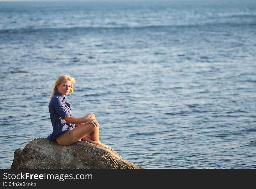 Girl Is Sitting On A Rock Near The Sea